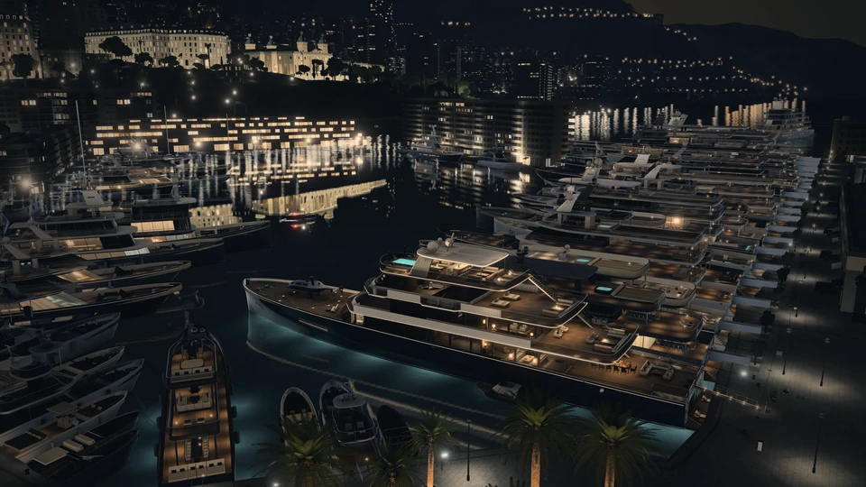 The last view, by night: HALCYON VI lit at the end of her row, the harbour’s lights on the water and Monte-Carlo beyond.
